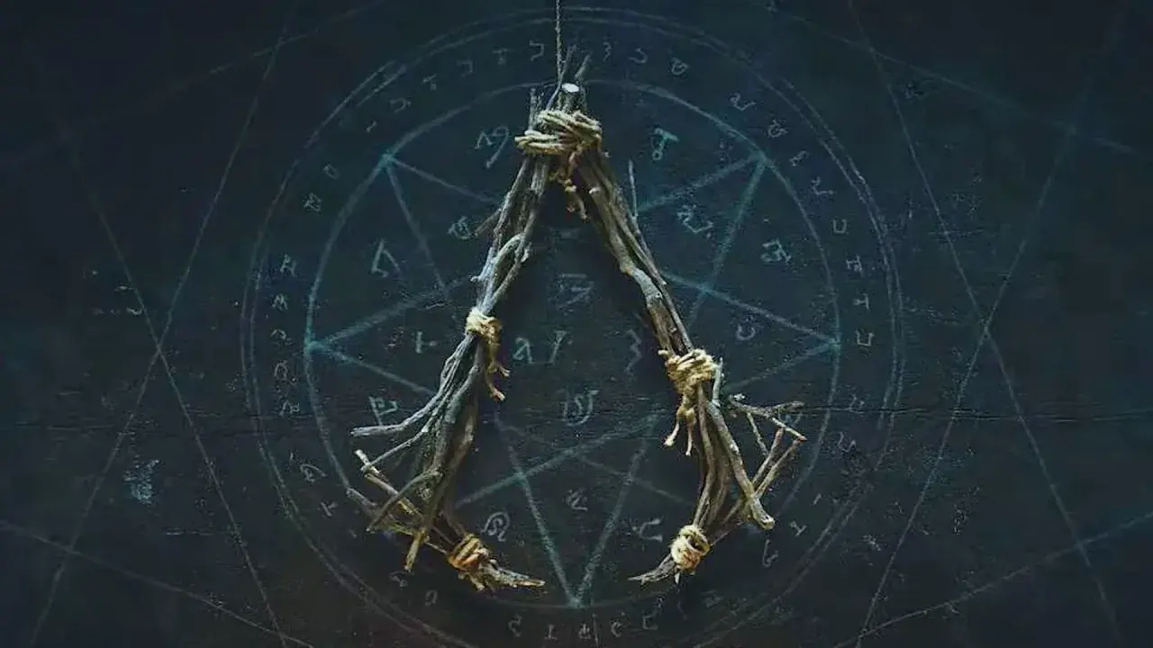 Wisiorek z gałązek, związany sznurkiem, na tle tajemniczego okręgu z symbolami. Może to być amulet ac hexe.