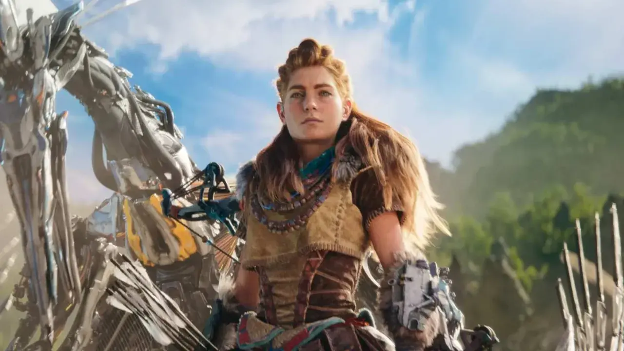 Aloy z Horizon 3 kiedy walczy z mechanicznym stworzeniem na tle gór i błękitnego nieba.