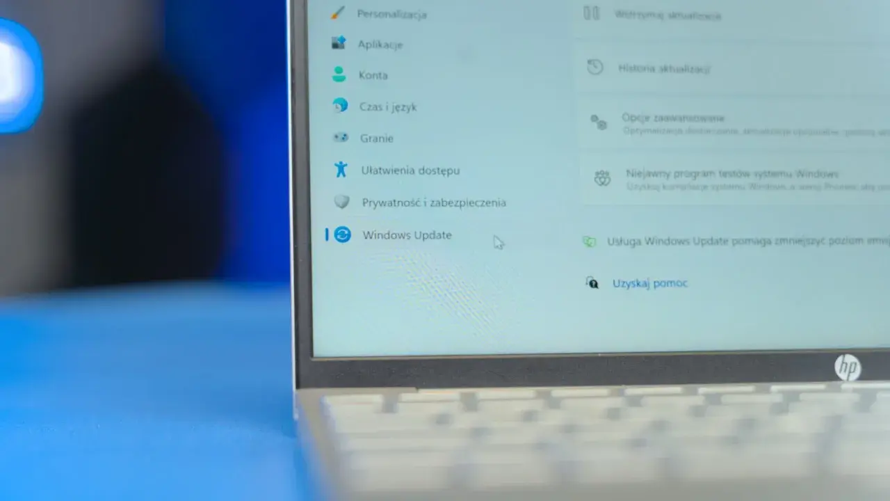 Ekran laptopa z menu Ustawień Windows 11. Widoczna opcja "Windows Update" i jej funkcje, takie jak wstrzymanie aktualizacji.