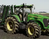Zielony traktor John Deere 7730 z agregatem uprawowym, gotowy do pracy w polu w grze Ursus FS19.