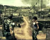 Chris i Sheva w zrujnowanej wiosce, przygotowani do walki w Resident Evil 5 Remake.
