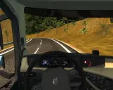 Widok z kabiny ciężarówki w ETS2. Widać kierownicę, deskę rozdzielczą z prędkościomierzem i obrotomierzem, a także lusterka boczne. Na drodze widać znak ograniczenia prędkości 60. Retarder jest kluczowy na zjazdach.