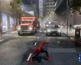 Spider-Man w deszczowym mieście, gdzie nagłe spadki FPS utrudniają pościg. Wóz strażacki i inne pojazdy na ulicy.