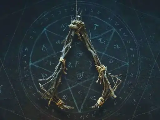 Wisiorek z gałązek, związany sznurkiem, na tle tajemniczego okręgu z symbolami. Może to być amulet ac hexe.