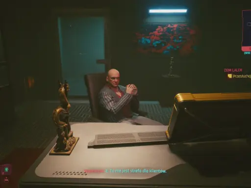 W cyberpunkowym domu lalek, Woodman siedzi w fotelu, groźnie patrząc. Na biurku leży klawiatura, a obok smoczy posąg.