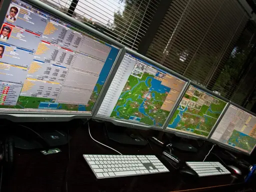 Wielomonitorowy pulpit gracza w grze **cargo tycoon**. Widok mapy i wykresów finansowych.