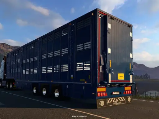Ciemnoniebieska naczepa do przewozu zwierząt w grze ets2 scs, jadąca malowniczą drogą.