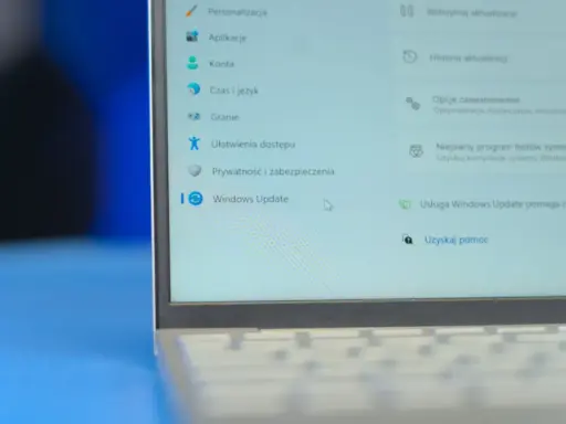 Ekran laptopa z menu Ustawień Windows 11. Widoczna opcja "Windows Update" i jej funkcje, takie jak wstrzymanie aktualizacji.