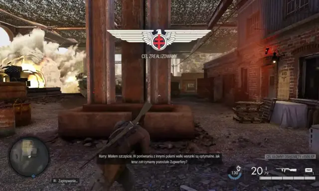 Gracz w Sniper Elite 3 poradnik, cel zrealizowany, eksplozja w tle.