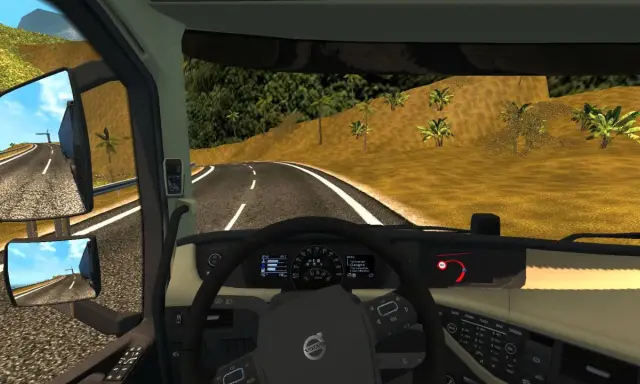 Widok z kabiny ciężarówki w ETS2. Widać kierownicę, deskę rozdzielczą z prędkościomierzem i obrotomierzem, a także lusterka boczne. Na drodze widać znak ograniczenia prędkości 60. Retarder jest kluczowy na zjazdach.