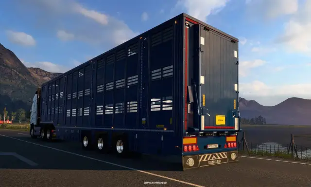 Ciemnoniebieska naczepa do przewozu zwierząt w grze ets2 scs, jadąca malowniczą drogą.