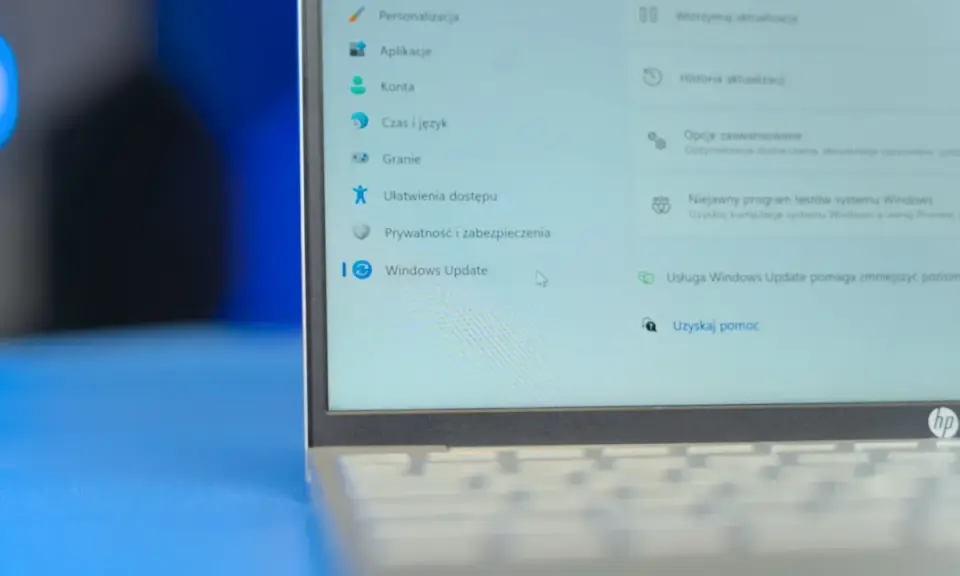 Ekran laptopa z menu Ustawień Windows 11. Widoczna opcja "Windows Update" i jej funkcje, takie jak wstrzymanie aktualizacji.