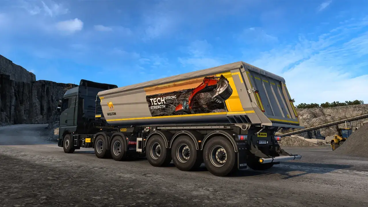 Ciężar&oacute;wka z naczepą do przewozu materiał&oacute;w sypkich w grze ETS 2. Naczepa ma grafikę koparki i napis 