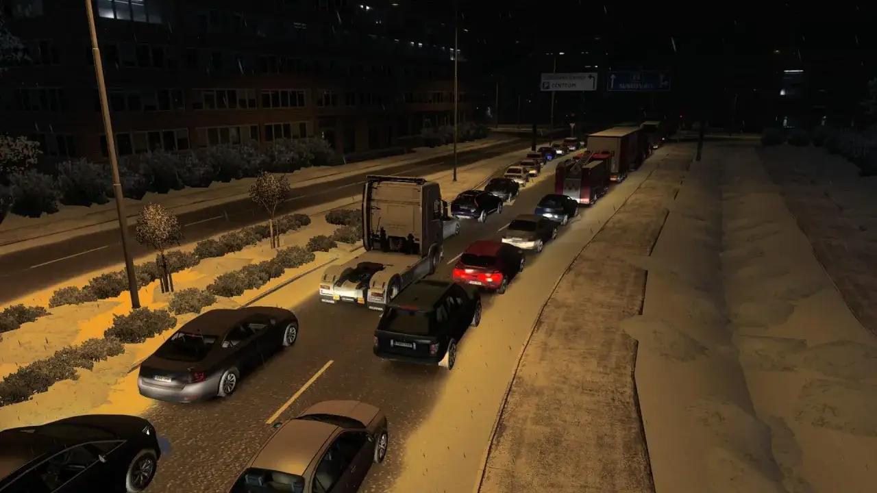Korek w grze ETS2. Wiele samochod&oacute;w stoi w korku nocą, widać też ciężar&oacute;wkę i w&oacute;z strażacki.