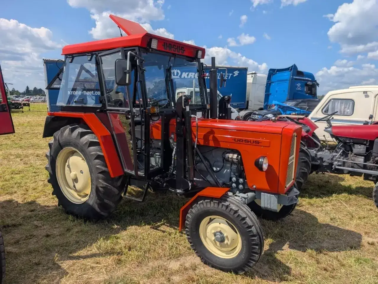 Czerwony Ursus FS19 z kabiną, gotowy do pracy na polu.